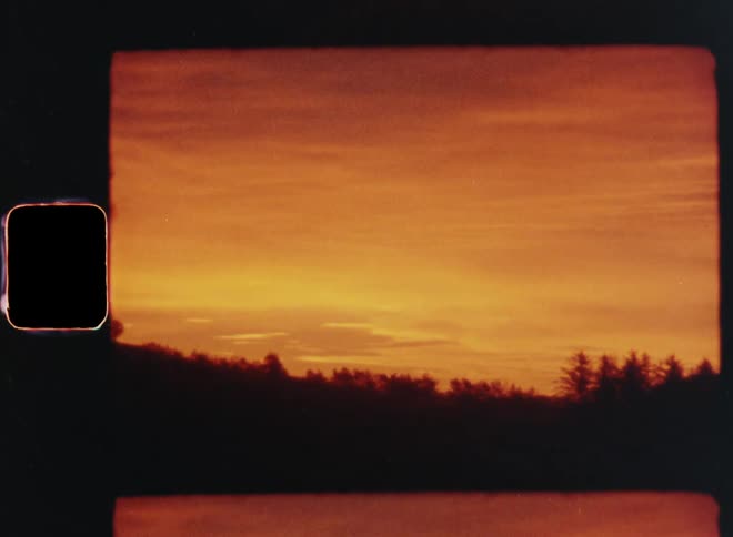 Landscape of hill with trees or tree tops of the forest being silhouetted against the red sky at sunset with afterglow or sunrise with vibrant orange colors