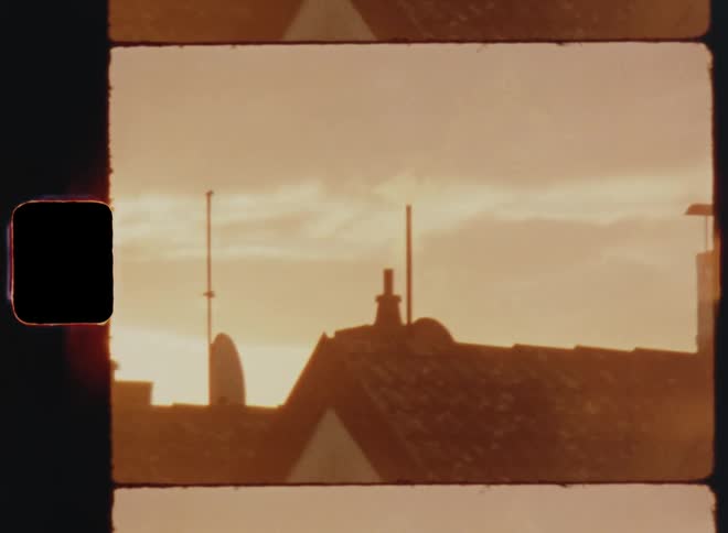 Smoke rises from chimney on home under an overcast sky