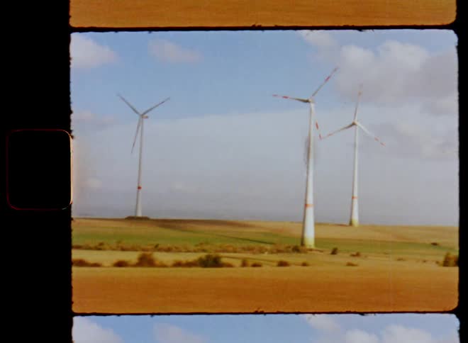 Film footage of wind turbines are displayed