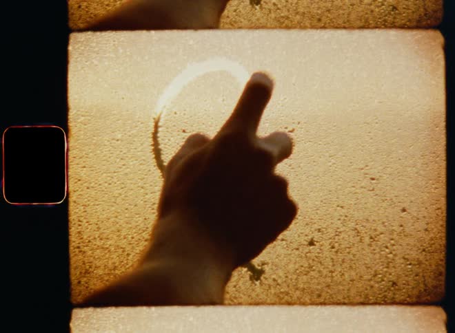 A man drawing a heart on a steamy window