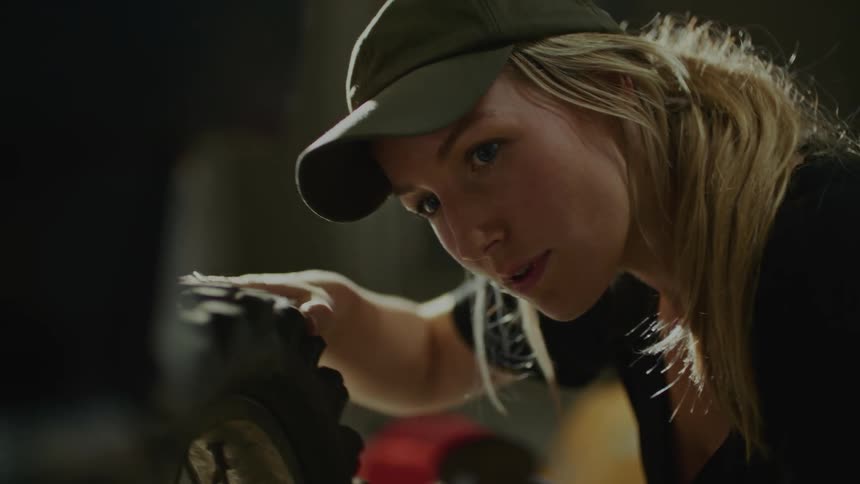 A woman is turning a wheel on a bicycle