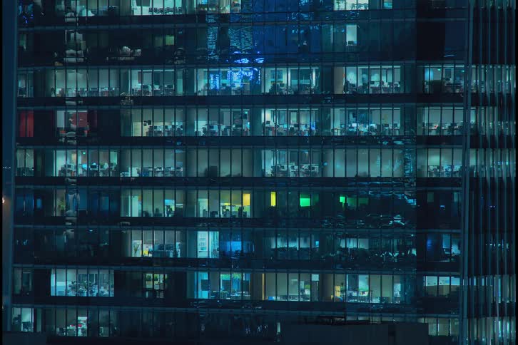 Workers in a multistory office building work through the night