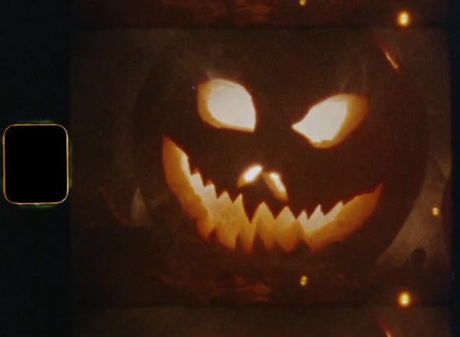 2 carved jack o lanterns glow from within while smoking due to the inner fire while they are illuminated by a bright flash light causing panic and stress at night on 31st October on vintage 8mm film with a nostalgic vibe