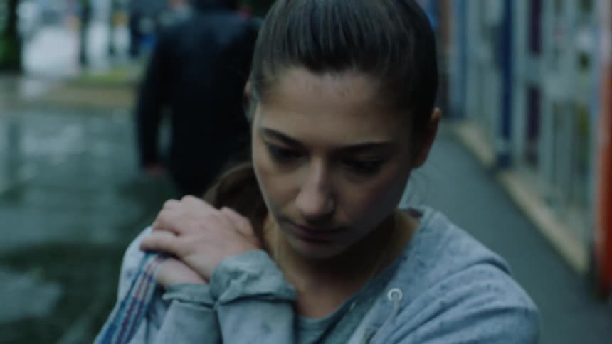 Woman with ponytail and gray jacket walks down the street and bumps into man