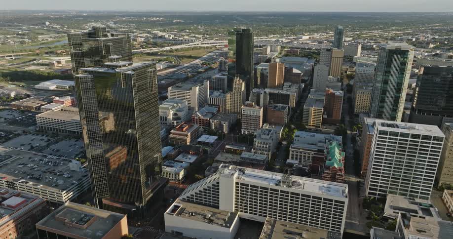 A city is shown from above that includes several buildings streets and cars