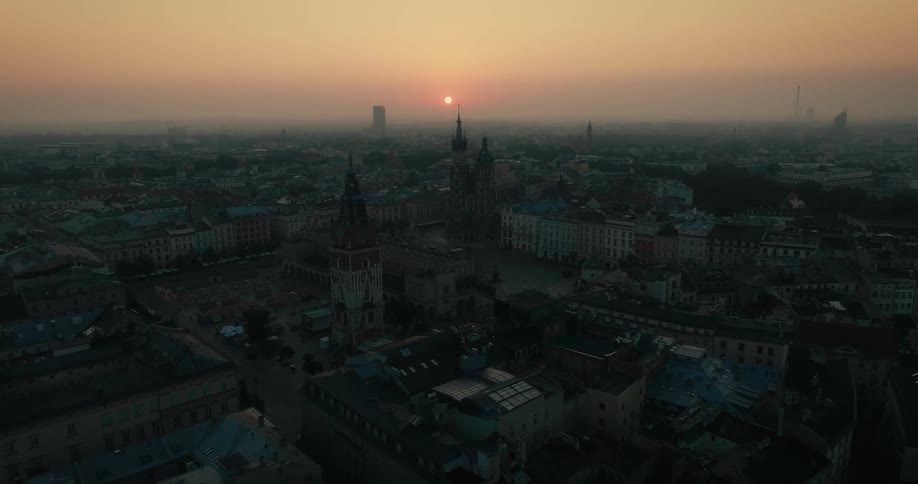 An aerial of a city with tall clock towers and multiple buildings
