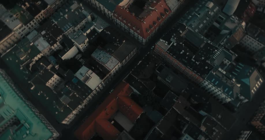 Cars are parked on the street in a crowded European city with buildings close together