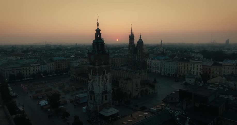 Aerial view and flight over a churchs towers in a large city at sunset