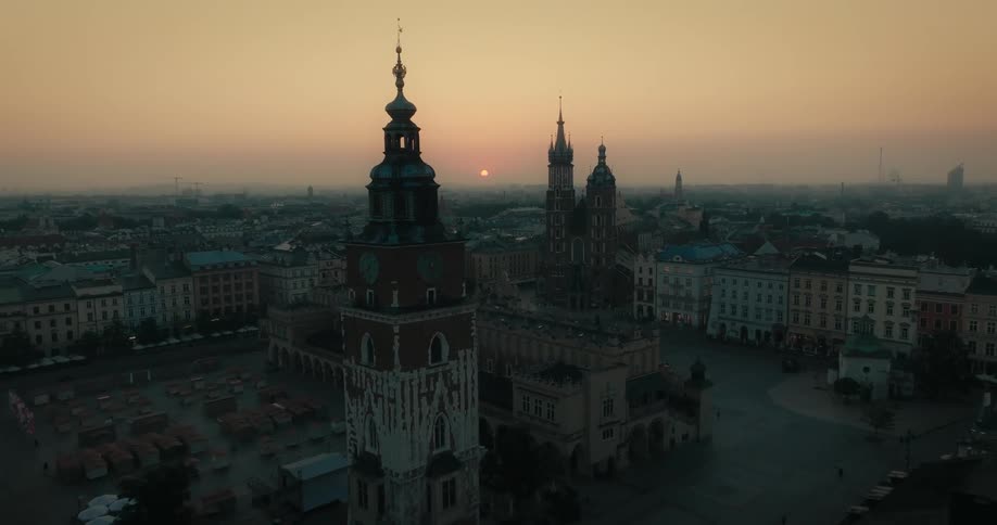 An aerial view of a city with large clock towers and buildings at dusk