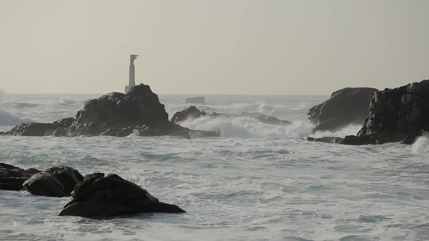 Rough waves crash against the rocks