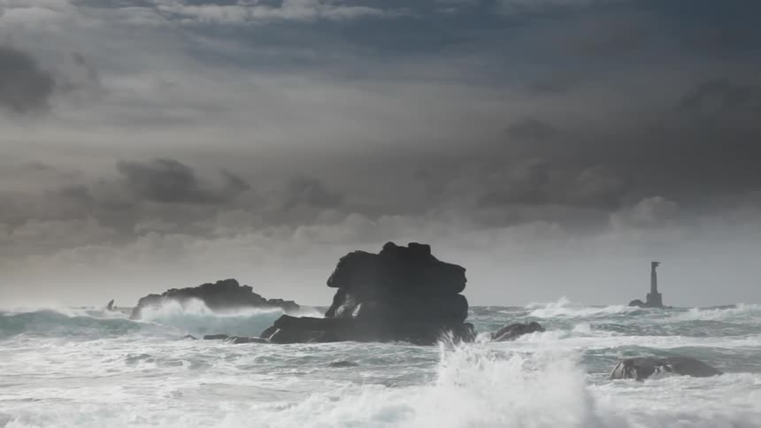 Rough waves crash against rocks in the ocean