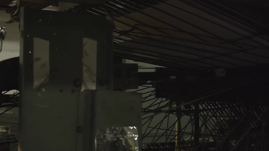What looks like some sort of vintage printer is shown with a piece of paper running through a conveyer belt with several bulky metal components to the other side