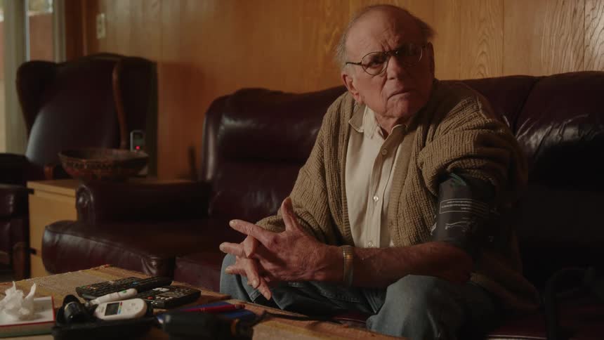 Elderly man sitting on a couch at home impatiently waiting for his blood pressure results