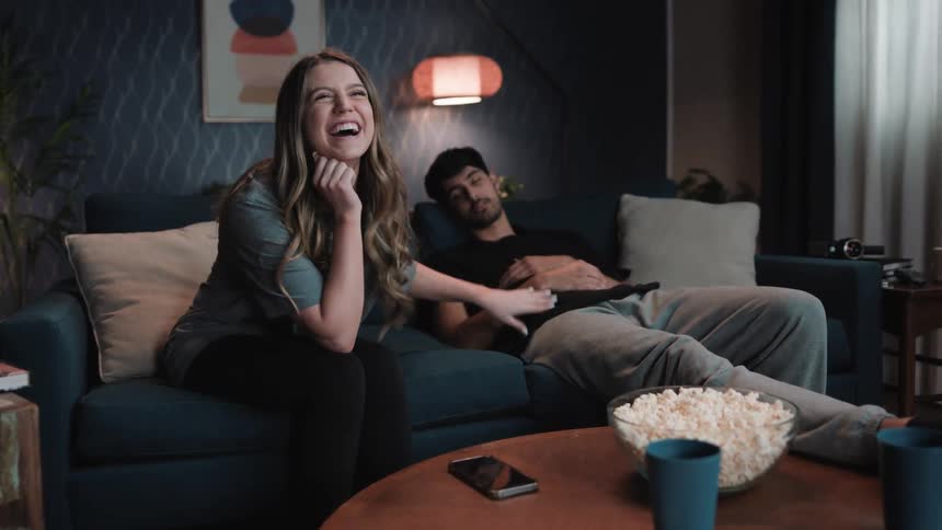 A woman wakes up a man to look at the show they are watching