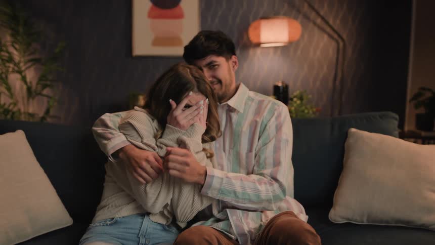A man and woman react to a something they are watching