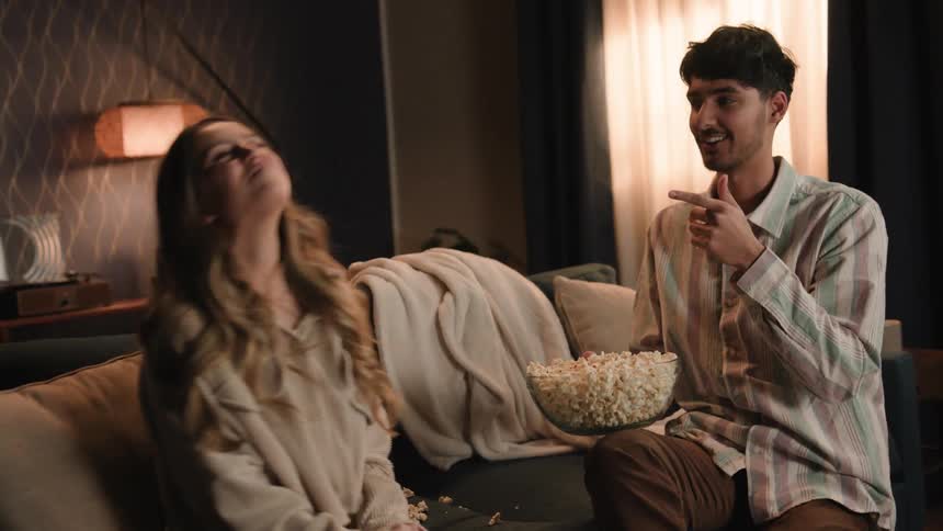 A man throws popcorn into a womans mouth