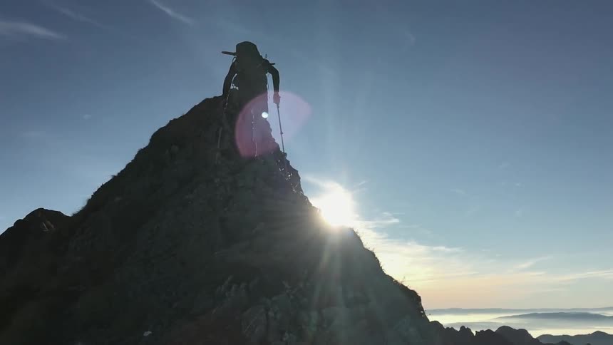 A person hikes up a mountain during the day