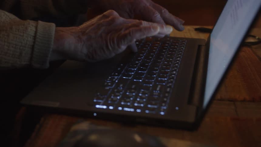 An older elderly man is on his laptop