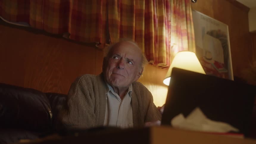 A man sits in front of his laptop
