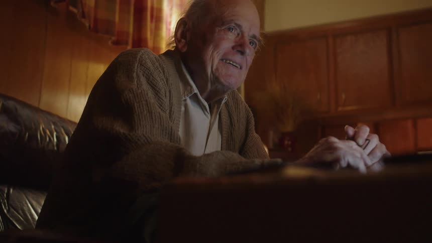 A man is smiling on the couch