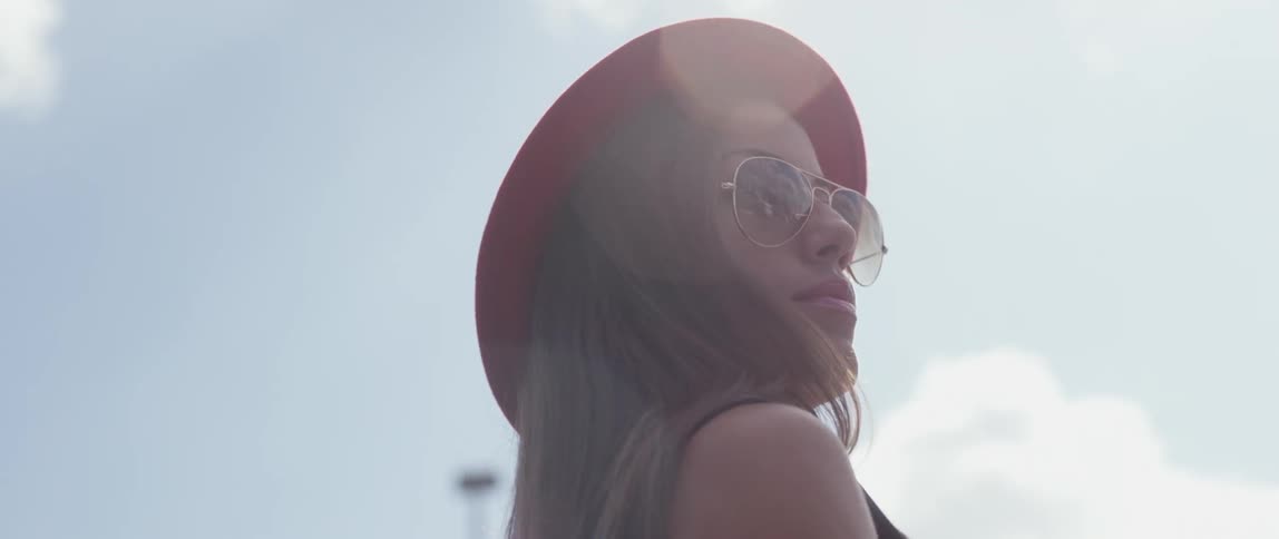 The sun shining down on a woman as she walks outside