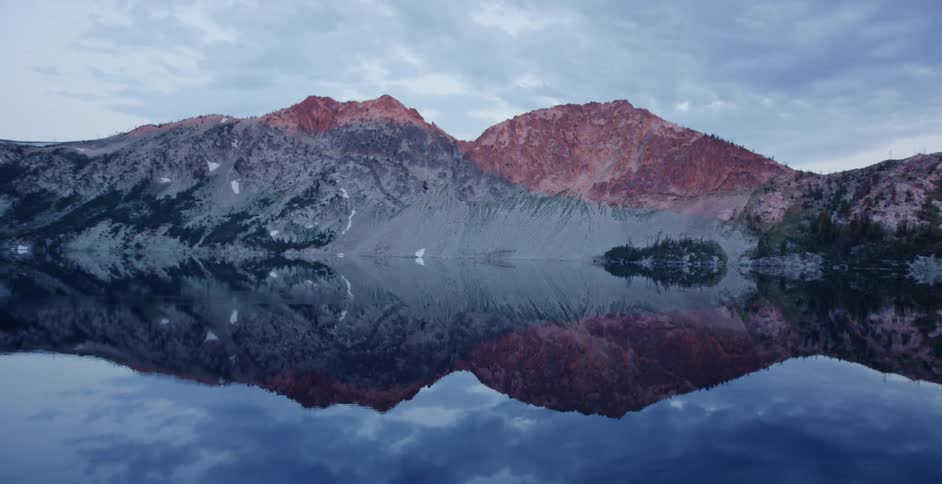 Panoramic view of the calm surface of a lake in the mountains at morning