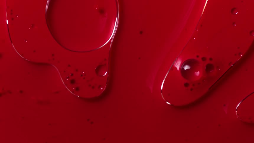 Crimson fluid flows onto pale mixture covering it