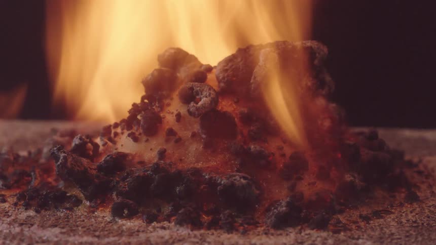 Burning flame chars pile of white sugar
