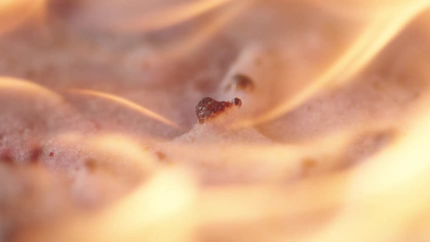 An up close view of a flame burning on a white substance