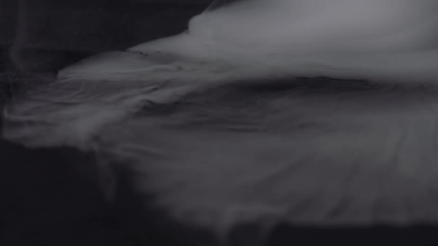Slomo movement of smoke or steam appearing like clouds against a black background