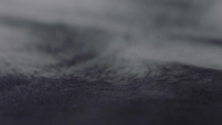 An up close view of grey material with steam or mist coming off it