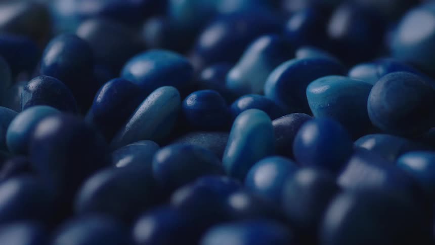A large pile of small blue rocks are spinning