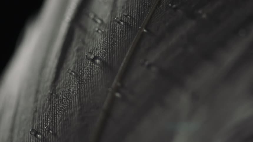 A gray material with ridges and water droplets on it