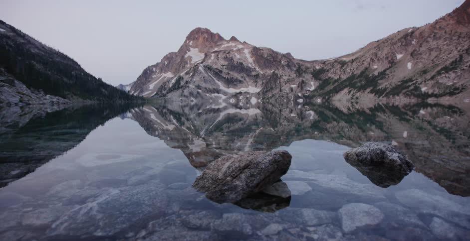 A lake surrounded by rocky mountain peaks on each side