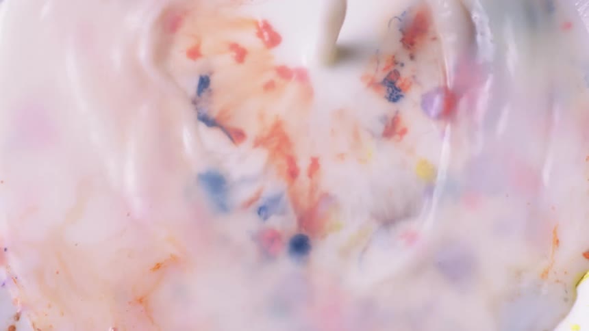 A liquid is poured atop a surface that appears to have many spots of dried