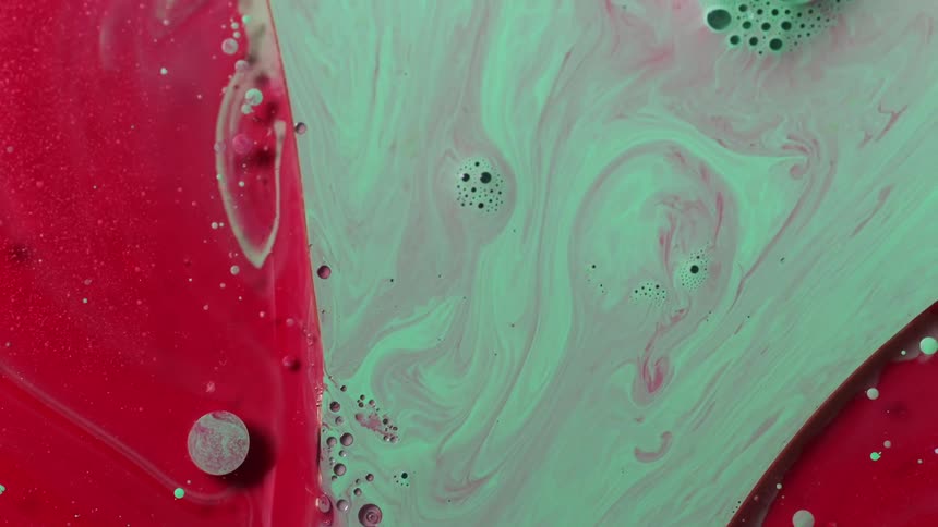 Turquoise and and red paints mixing and flowing