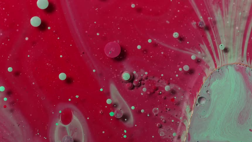 Close up of red and teal liquid ink flowing