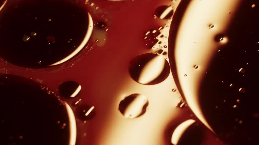 A light plays over some bubbles of liquid suspended in oil