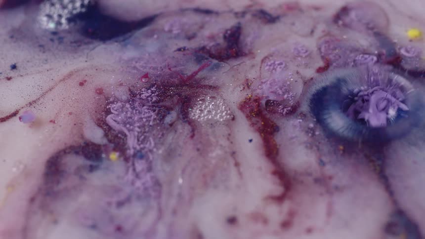 An up close view of colorful soapy liquid with bubbles and swirls