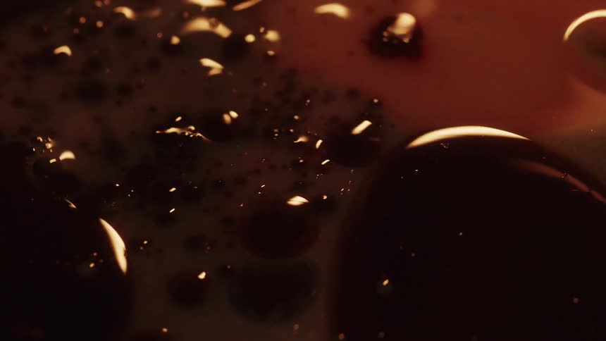 An up close of dark paint bubbles up and swirling around