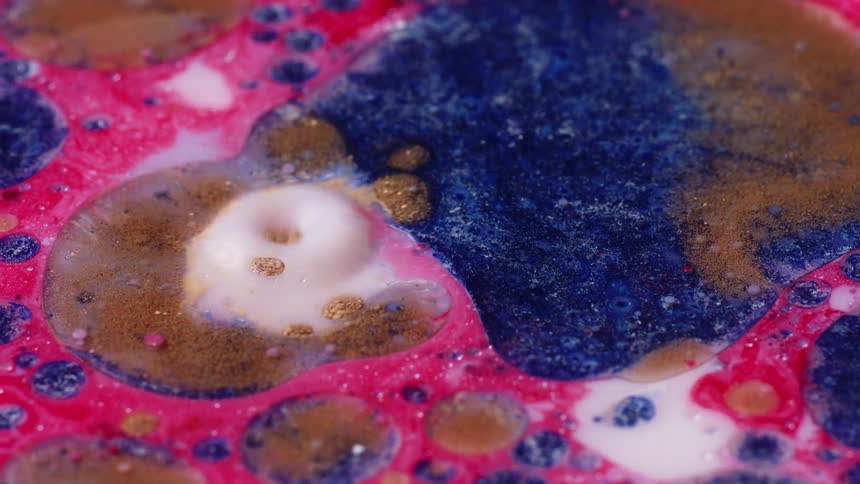 A close up of colorful bubble water with droplets dripping into it