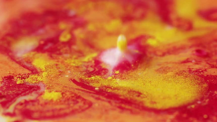 Droplets fall into a colorful creamy liquid