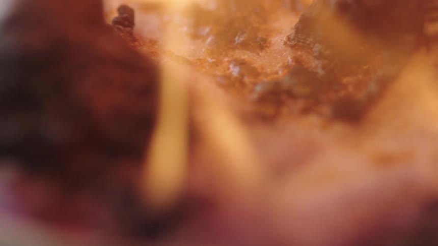 Flames waver and move as a charred substance bubbles and burns