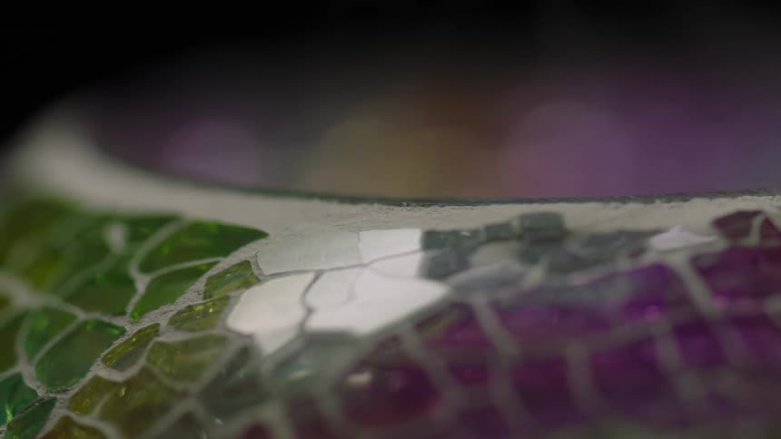 An up close of clear green yellow and purple gemstones on a vase