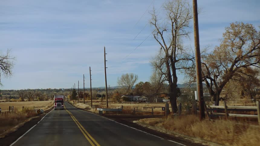 Truck is driving on a highway through a rural area