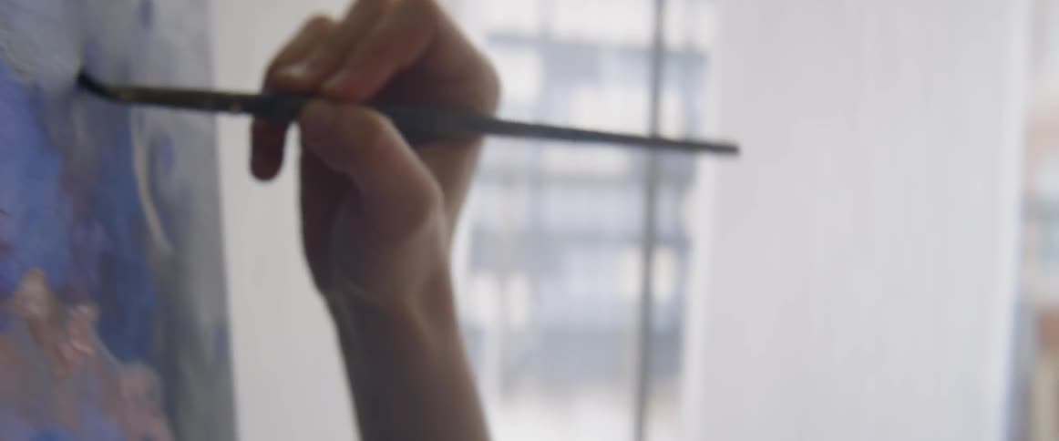 Woman painting on a piece of canvas