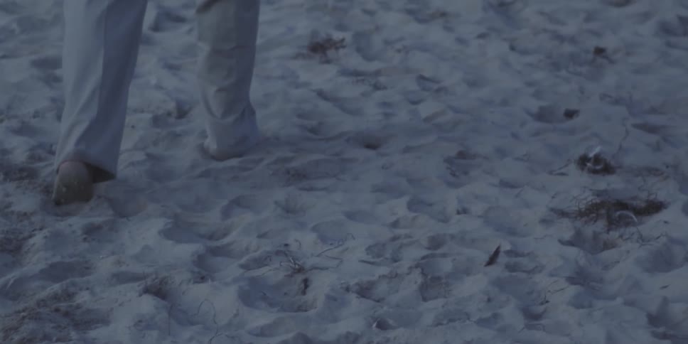 A person walking barefoot in the sand