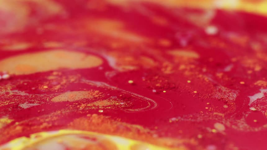 An up close of red and yellow paint swirled around