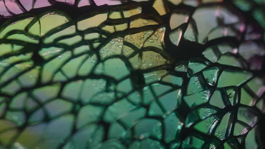 Extreme close up of the details on a stained glass window reflecting light