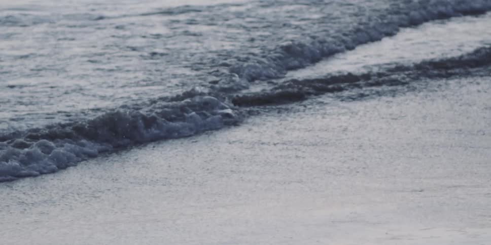 Waves crash to the shore of a beach
